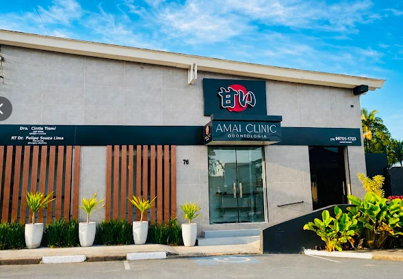 Fachada da AMAI Clinic Odontologia, com entrada de vidro, jardim e rampa de acesso